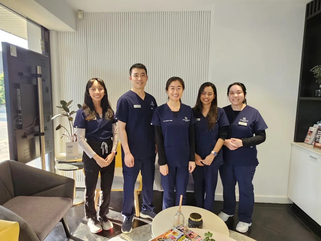 The Dental Implant Centre Sydney team in navy scrubs in the West Ryde clinic reception